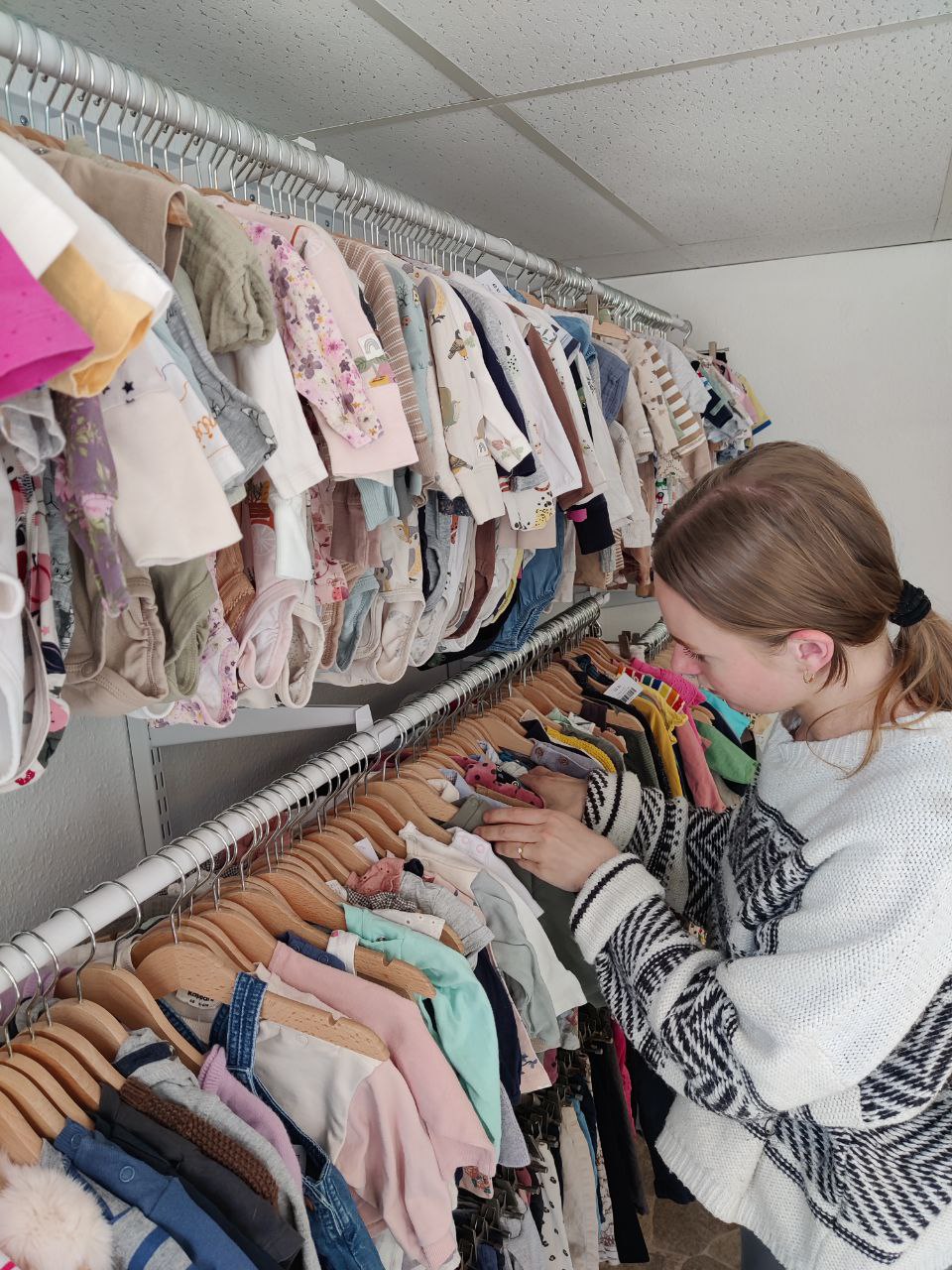 Alicia arbetar i Lilleman & Jag butiken bland välorganiserade barnkläder